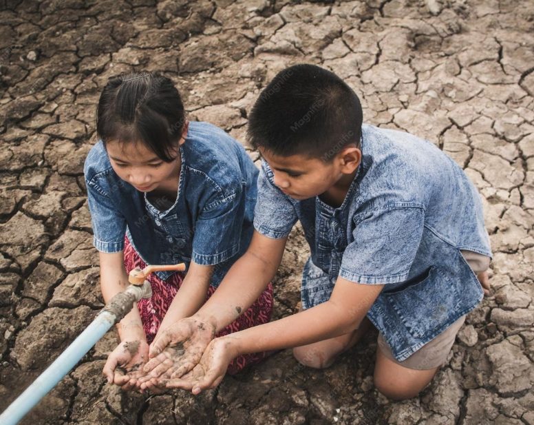 Anak-anak di dekat pipa air di tanah kering